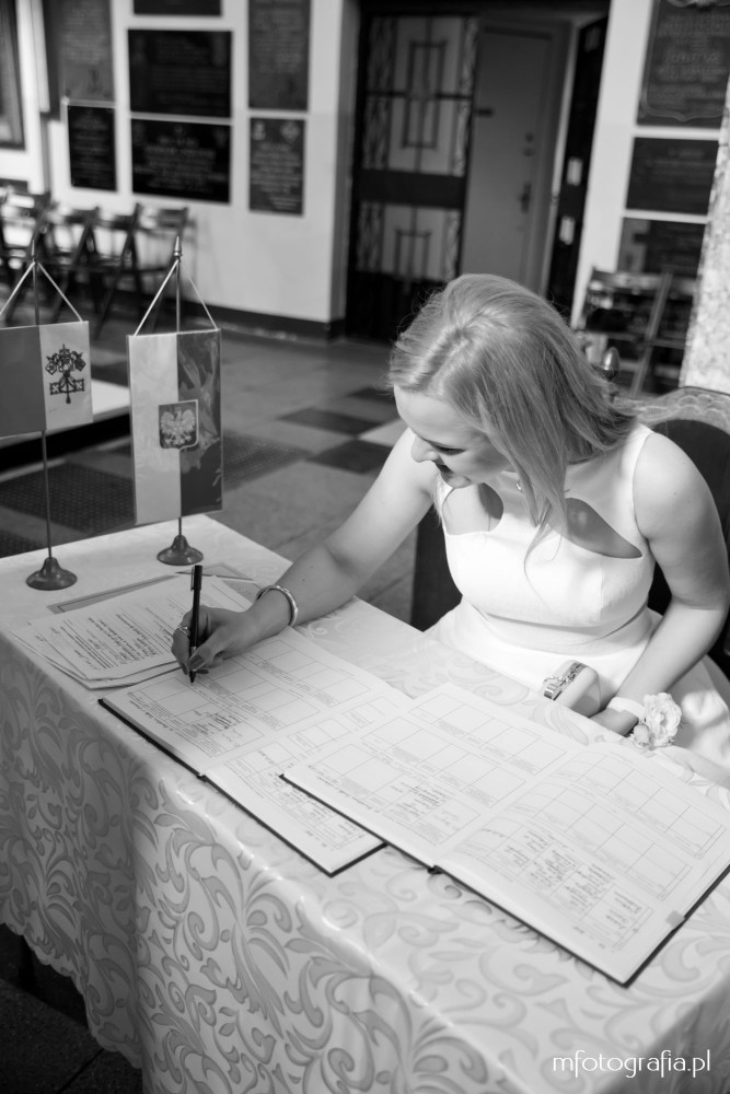 fotografia ślubu - świadkowa podpisuje dokumenty